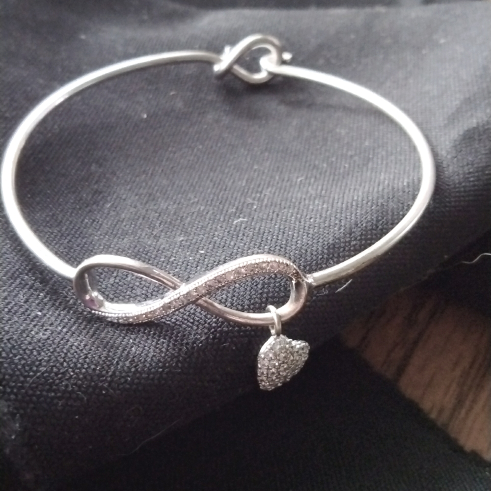 Beautiful silver bangle infinity bracelet with dainty dangling heart charm!